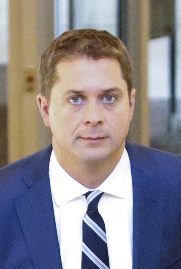 Ein Mann im Anzug und Krawatte geht einen Flur entlang mit einem unscharfen Hintergrund, der besorgt wirkt.