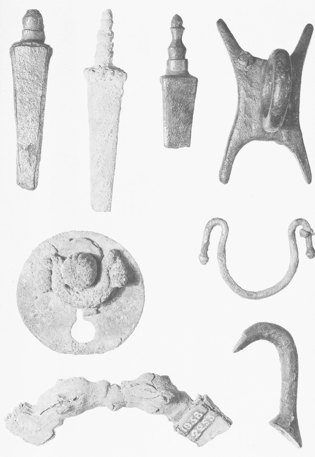 Schwarzes und weißes Bild von neolithischen Artefakten, einschließlich Metallgegenständen, auf einer weißen Oberfläche.