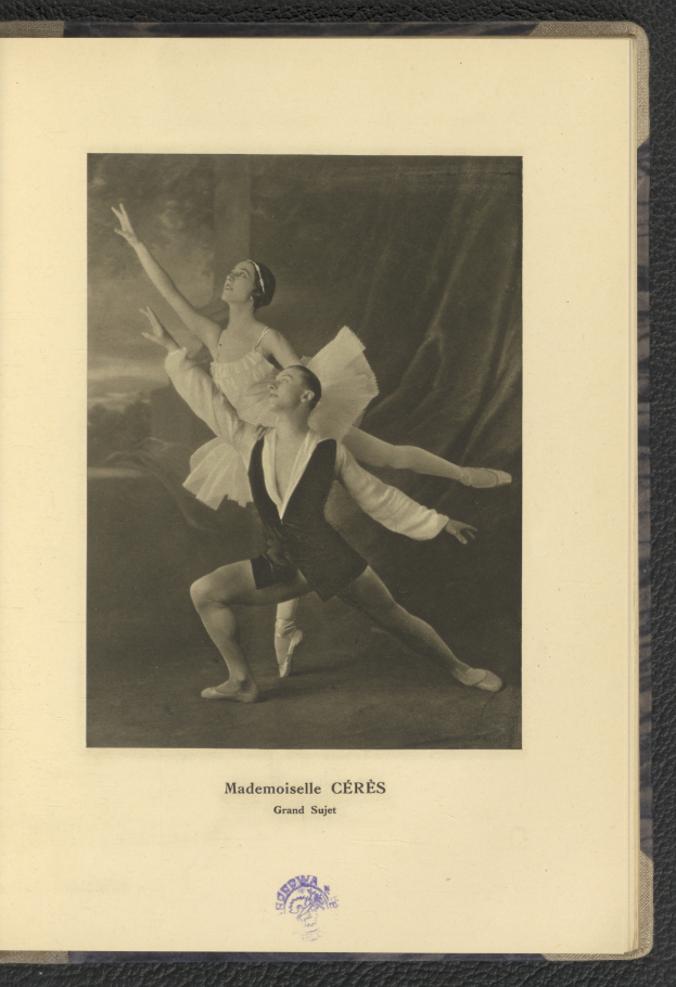 Ein Schwarz-Weiß-Foto eines Mannes und einer Frau in Ballettkleidung, die perfekt synchron tanzen, wobei der Mann ein weißes Tutu trägt und die Frau ein rosafarbenes Kleid trägt, Text am unteren Bildrand.