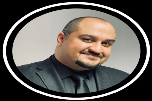 Ein lachender Mann im Anzug und Krawatte vor einem schwarzen Hintergrund, betitelt mit "Anwalt in New York City."