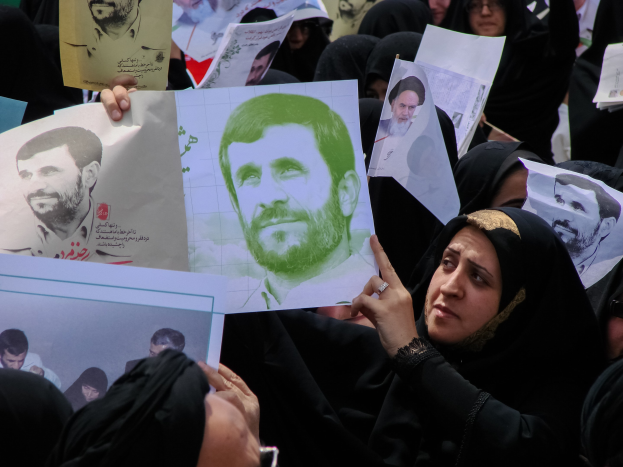 Eine Gruppe iranischer Frauen in schwarzer Kleidung, einige mit Brille, halten Bilder von Präsident Mahmoud Ahmadinejad während einer Demonstration in Tehran hoch.