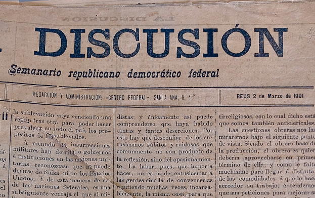 Eine gelbliche, leicht zerknitterte Zeitung mit der schwarzen Schrift 'Diskussion' darauf, die die Überschrift 'Semanario Republicano Democrático Federal' trägt.