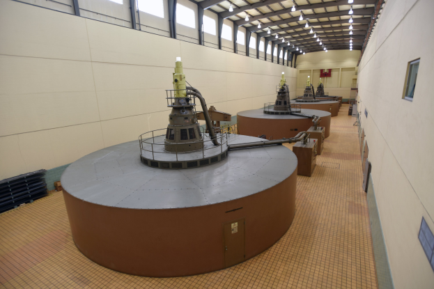 Großer Raum mit zahlreichen Metalltanks, Industriegeräten und Deckenlampen, wahrscheinlich Teil einer Kernreaktoranlage.