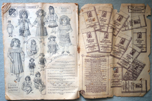 Ein aufgeschlagenes Buch mit Bildern von Kindern und Puppen auf einer blauen Oberfläche, das Text und Bilder enthält, die einen Blick in die Vergangenheit ermöglichen.